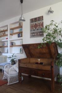 ein Klavier in einem Wohnzimmer mit einem Stuhl und Regalen in der Unterkunft La Tinaia del Glicine in Pratolino