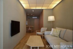 uma sala de estar com um sofá e uma mesa em IORI Stay em Takayama