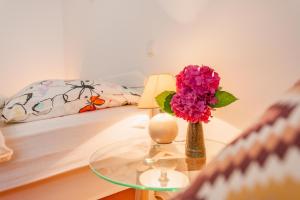 a table with a vase of flowers and a bed at DREAM Bled Apartments in Bled +11 photos