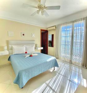 a bedroom with a blue bed with a ceiling fan at Hotel Shakey in Santo Domingo