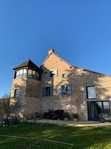 a large brick building with a piano in front of it at L’En Vert du Monde in Saint-Boil