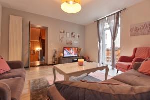 uma sala de estar com dois sofás e uma mesa em Maison LAMARTINE - Plein Centre-Ville Avec Garage & Jeux em Saint-Claude