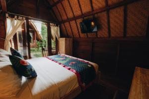 Una cama o camas en una habitación de Kubu Kak Dudung Villas