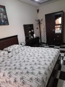 a bedroom with a large bed with a comforter on it at Al-marsa2 in Al Hoceïma