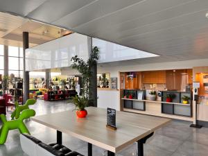 a dining room with a table and chairs in a building at Campanile Metz Nord Woippy- Porte du Luxembourg A31- Confort Climatisé- Air Conditionning in Woippy