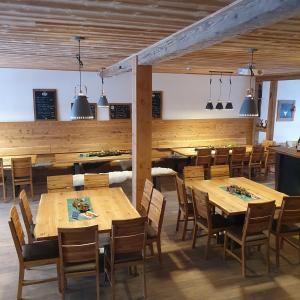 a dining room with wooden tables and chairs at Alte Backstube - Ferienwohnung Hüttenstube und Ferienzimmer Auszeit in Erkenbrechtsweiler