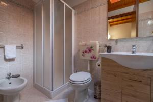 a bathroom with a toilet and a sink at Happy Guest Apartments - Lake & Green Oasis in Riva di Solto