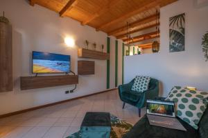 a living room with a couch and a tv on a wall at Happy Guest Apartments - Lake & Green Oasis in Riva di Solto