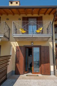 a house with a balcony with two chairs on it at Happy Guest Apartments - Lake & Green Oasis in Riva di Solto