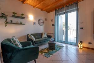 a living room with couches and a large window at Happy Guest Apartments - Lake & Green Oasis in Riva di Solto +10 photos