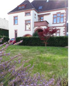 a house with a yard with purple flowers in front of it at living TIMELESS- Europa Park- Kippenheim in Kippenheim