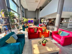 Habitación con sofás coloridos y mesa de centro. en Campanile Metz Nord - Woippy, en Woippy
