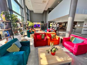 a room with colorful couches and a coffee table at Campanile Metz Nord - Woippy in Woippy