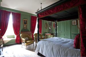 a bedroom with a large bed and red curtains at The Great House B&B in Timberscombe