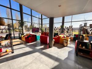 a large room with couches in a room with windows at Campanile Metz Nord Woippy- Porte du Luxembourg A31- Confort Climatisé- Air Conditionning in Woippy