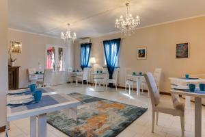 una sala da pranzo con tavoli e sedie bianchi di Il Giullare by agriturismo Borgo Castellaccia a Cesenatico