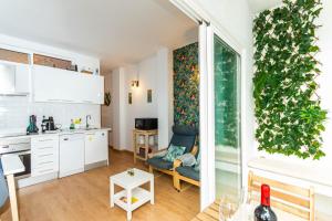 una cocina con armarios blancos y una planta verde en la pared en Apartment Azul Beach, en Las Palmas de Gran Canaria