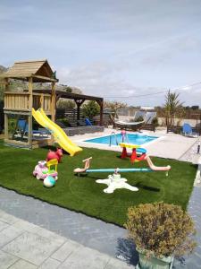 een achtertuin met een speeltuin met een glijbaan en een zwembad bij Stergios villa in Kolimbia