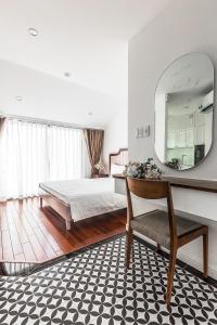 a bedroom with a bed and a mirror and a chair at Ngan Ha 2 Apartments in Ho Chi Minh City
