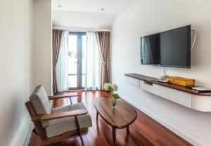 een woonkamer met een tv, een stoel en een tafel bij Ngan Ha 2 Apartment in Ho Chi Minh-stad +55 foto's
