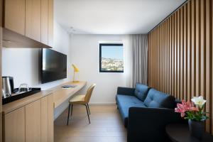 a living room with a blue couch and a tv at Sofia Hotel Sea Of Galilee in Tiberias