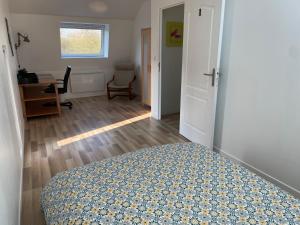 Schlafzimmer mit einem Bett, einem Schreibtisch und einem Fenster in der Unterkunft Au Soleil Vert in Mont-Bernenchon