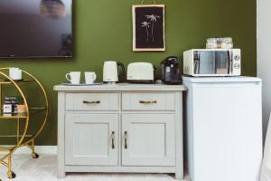a kitchen with a white cabinet with a microwave on it at Cherry Tree Lodge in Anstey