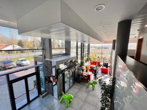 an open living room with a view of a car dealership at Campanile Metz Nord Woippy- Porte du Luxembourg A31- Confort Climatisé- Air Conditionning in Woippy