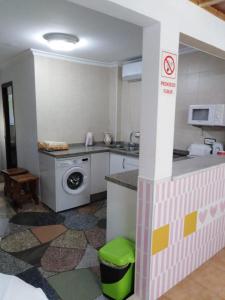 kuchnia ze zlewem i pralką w obiekcie The Cozy Home w mieście Gibraleón