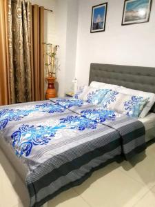 ein Bett mit einer blauen und weißen Bettdecke darauf in der Unterkunft Unit 1109 Cityscape Residences in Bacolod City