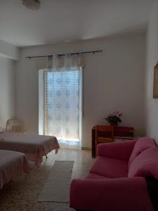 uma sala de estar com um sofá e uma janela em Finestra sul mare em Palizzi