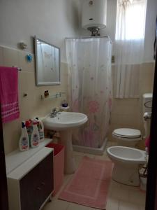 uma casa de banho com um lavatório e um WC em Finestra sul mare em Palizzi