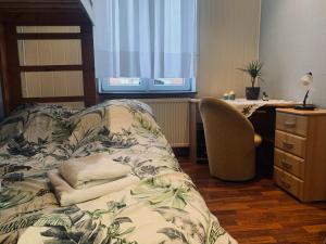 a bedroom with a bed with a desk and a chair at Apartament Kamienica Monciak in Sopot