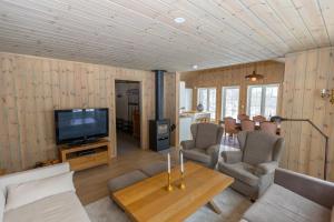 a living room with a television and a table at Sirdal near Kjerag in Tjørhom