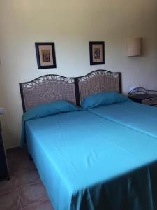 Bett in einem Zimmer mit blauer Decke in der Unterkunft Son Bou by The Sea; home with a private garden in Son Bou