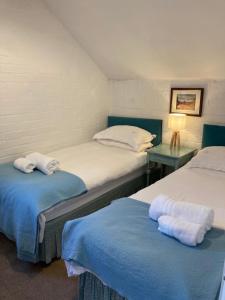 a bedroom with two beds with towels on them at The Hayloft in Abergavenny