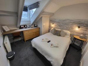 una camera da letto con un grande letto con asciugamani di Ashby House a Tenby