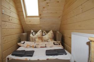 1 dormitorio con 1 cama en una cabaña de madera en Marang Domki i Apartamenty, en Szczyrk