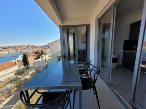 a blue table and chairs on a balcony with a view at Design apartments 3&4 in Mali Lošinj
