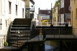 een brug over een rivier met trappen en gebouwen bij Onder de Linde B&B in Valkenburg