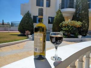 a bottle of wine sitting next to a glass at PALMAR CLUB - Villa MARYAM in Marathón