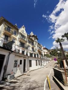 una fila de edificios blancos en una calle con una palmera en Apartments Anita in Villa Esperia, en Opatija