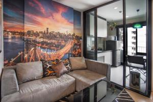 a living room with a couch in front of a large window at The Base Central apartments in Pattaya Central