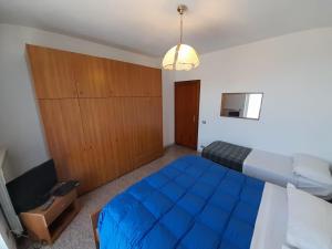 a bedroom with a large blue bed and a television at Agriturismo Riomaggiore Mare Monti in Rocchetta di Vara