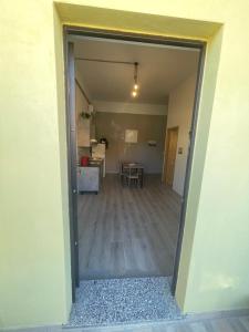 una puerta abierta a una sala de estar con mesa en La Casetta L&L, en Iglesias