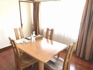 a wooden table and chairs in a room with a window at Golden Mile Apartment in Amami