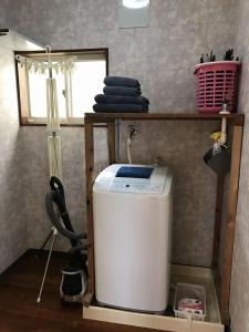 a laundry room with a washing machine and a window at Golden Mile Apartment in Amami