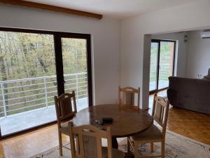 a dining room with a table and chairs and a large window at Porodicna kuca za odmor Kovaci in Zavidovići