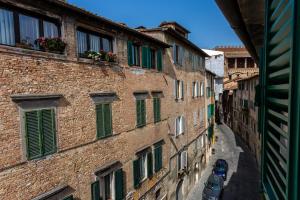 an alley in an old building with green shutters at La casa del Duprè in Siena