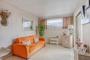 a living room with an orange couch in a room at APPARTEMENT LA GRANDE MOTTE (34280) in La Grande-Motte